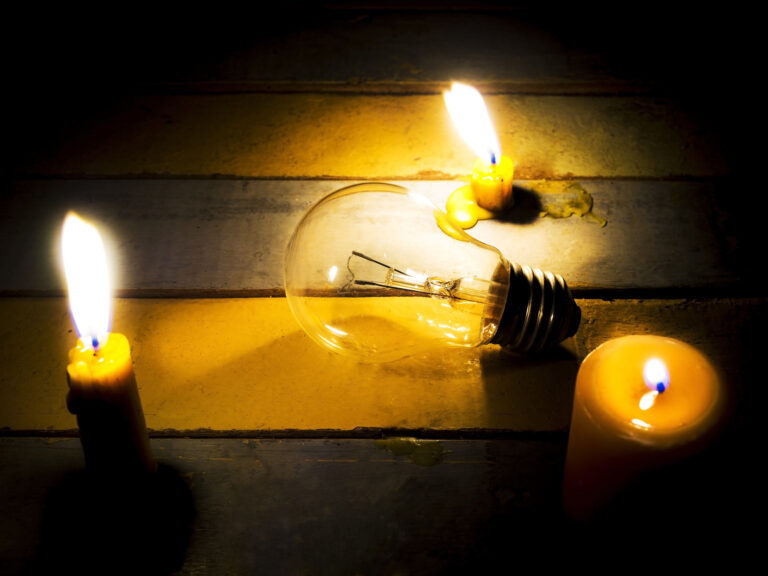 candle light shining on incandescent bulb