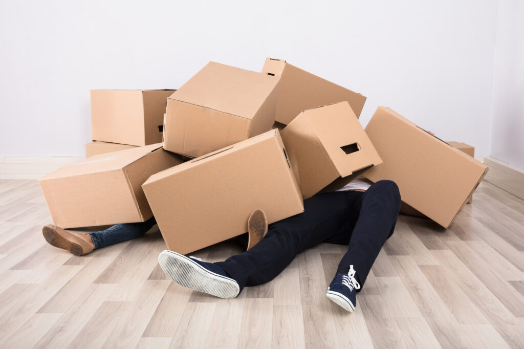 Couple Lying Under The Cardboard Boxes
