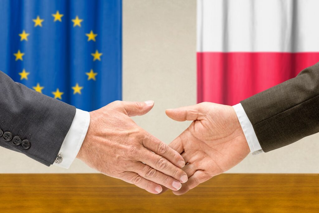 Representatives of the EU and Poland shake hands