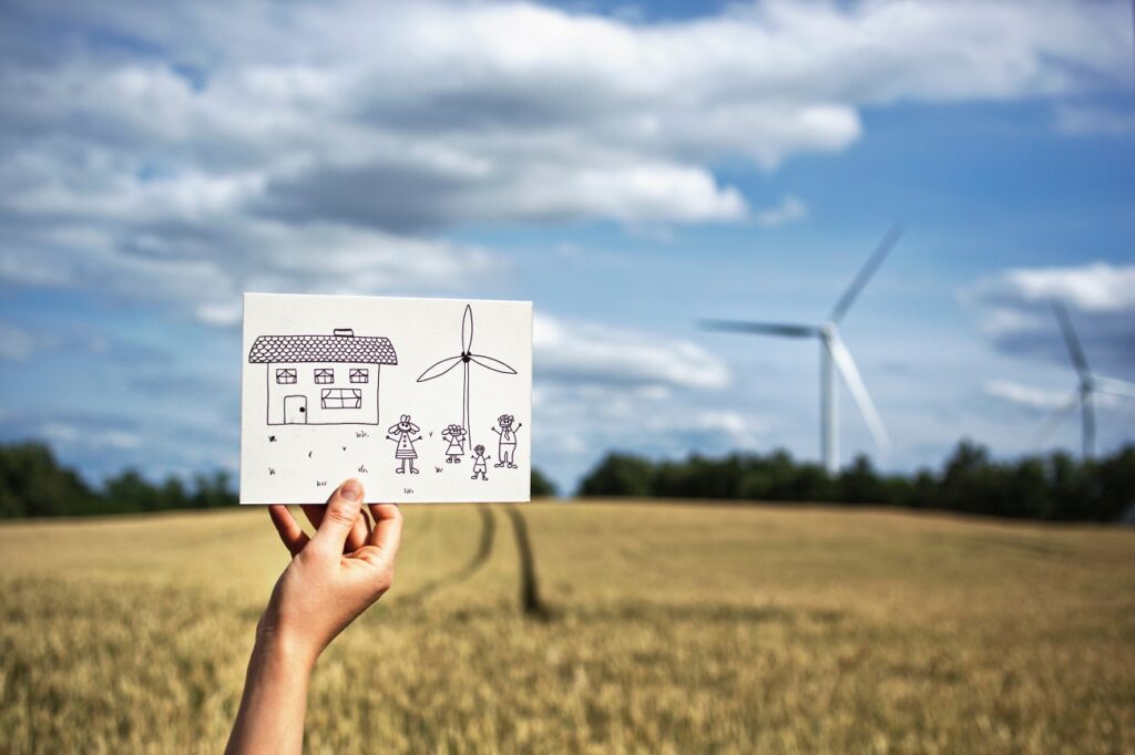 Woman with drawing at wind turbines
