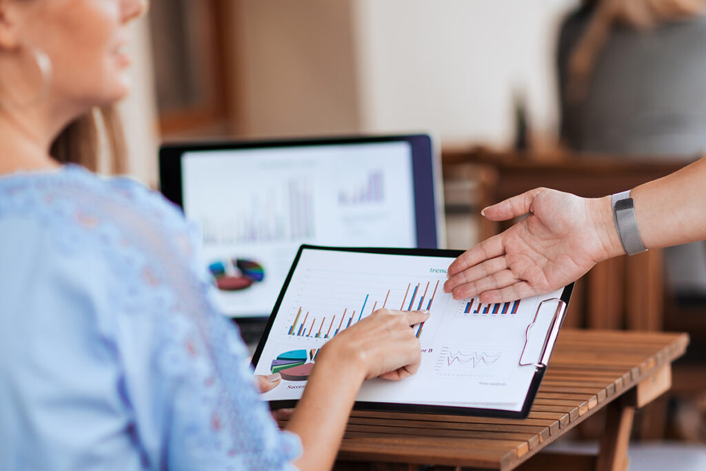 colleagues discussing financial data sitting at a table in a cafe.