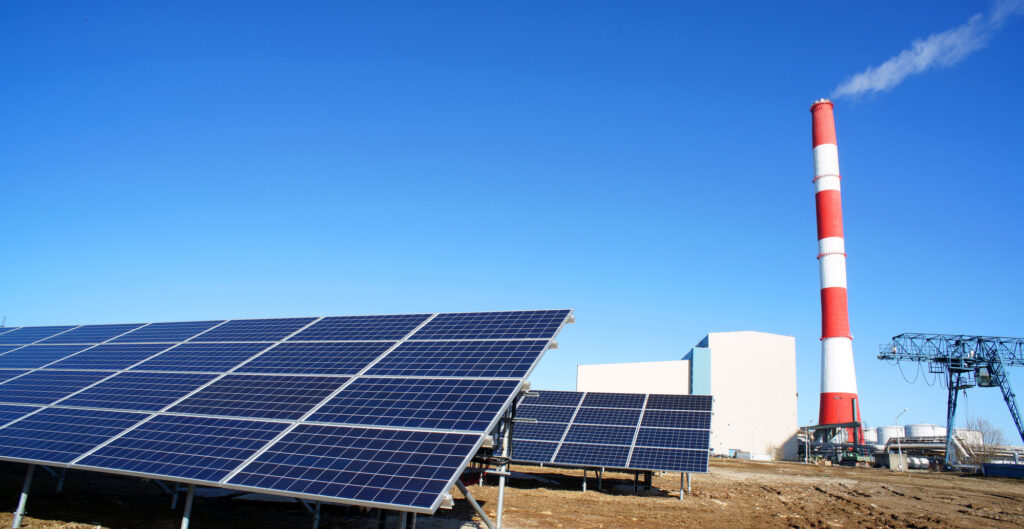 Solar panel, smokestack at power plant