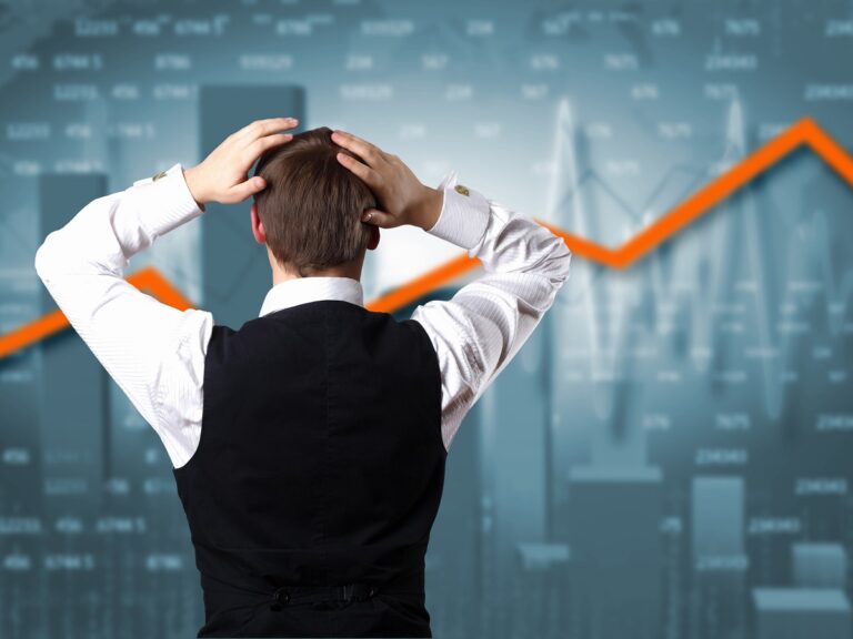 Young businessman against financial graphs
