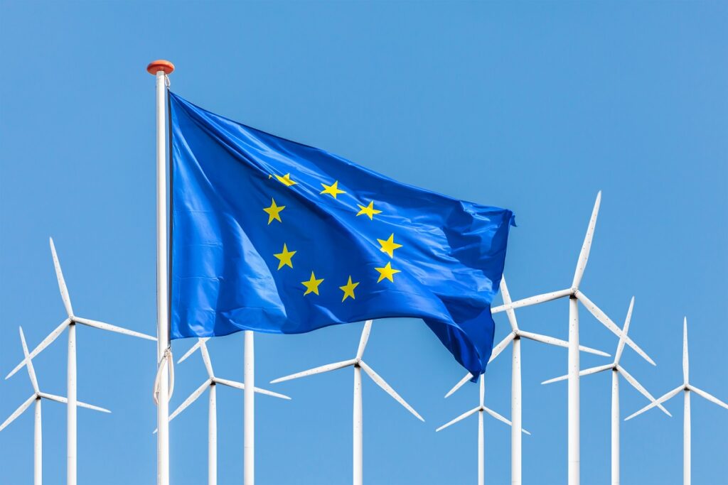 Flag of the European Union in front of a large windpark with win