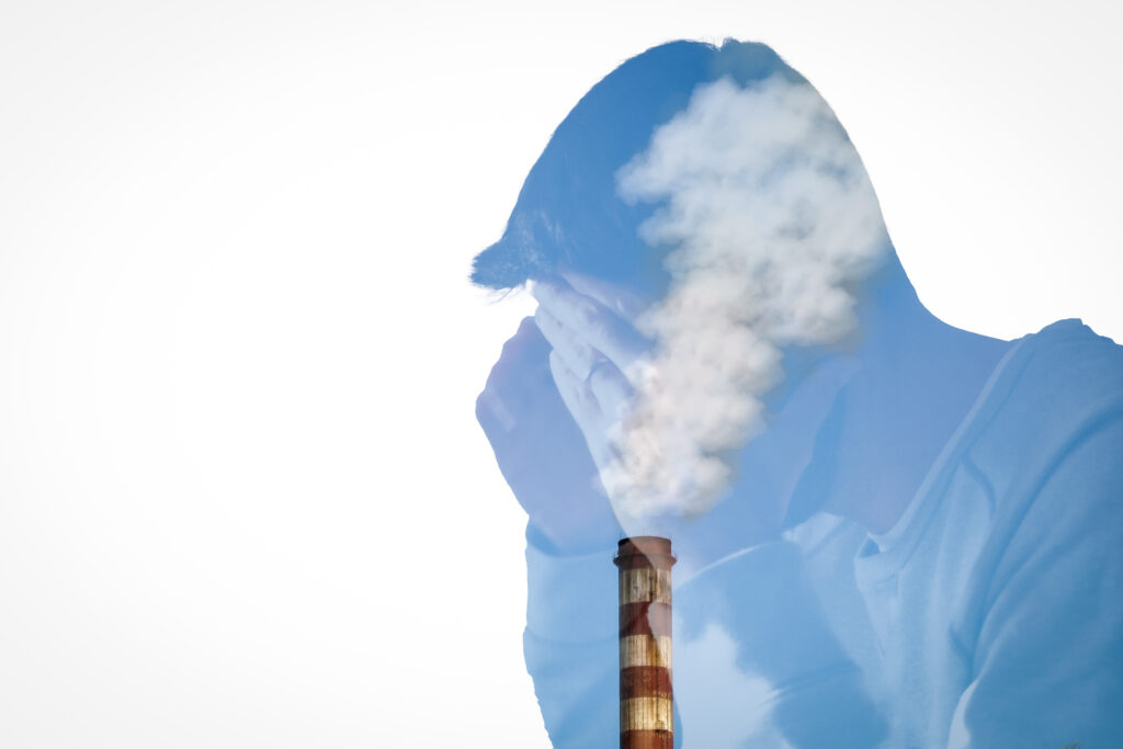 Double exposure. Silhouette of a Young troubled man combined with a smoky chimney
