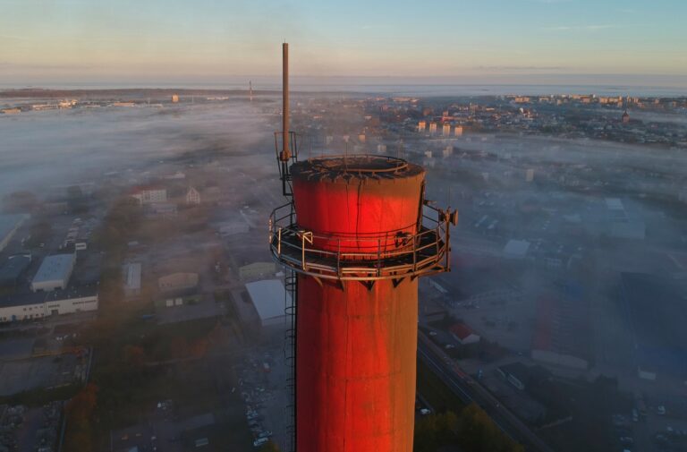 Aerial view on brick chimney and city covered in fog.