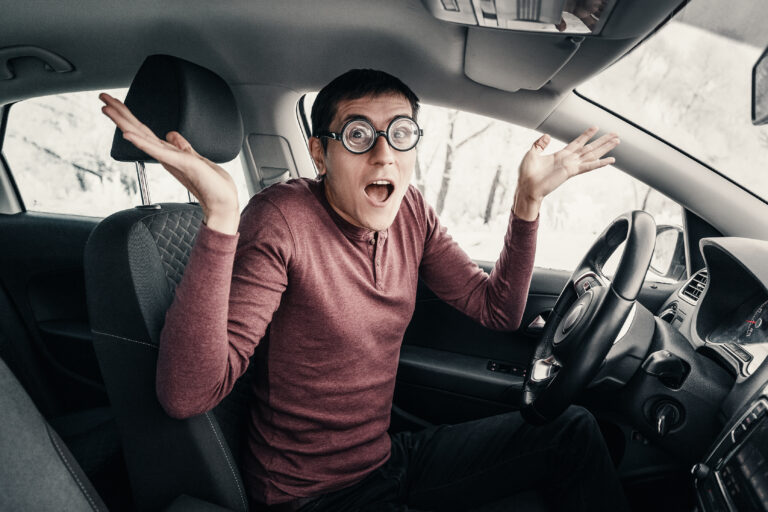 short sighted man with large glasses 5 diopters is surprised and annoyed that there was an accident with another car. Strongly gestures and expresses emotions