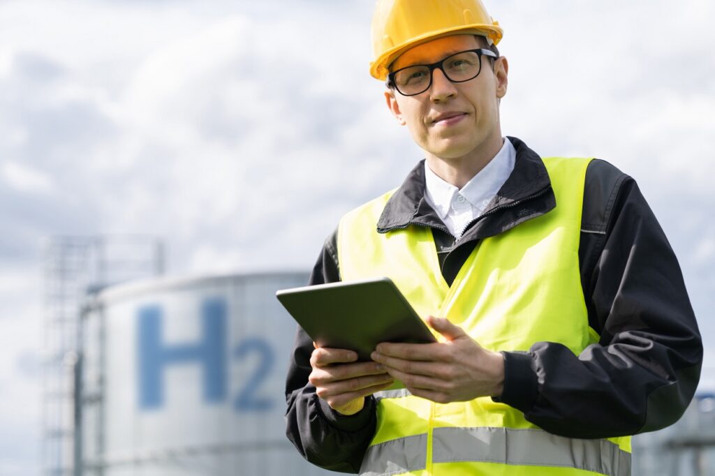 Engineer with tablet computer on a background of Hydrogen factory